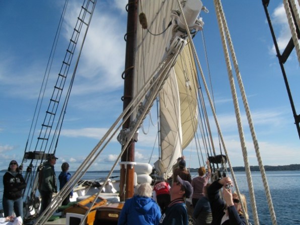 The crew unfurls the staysails