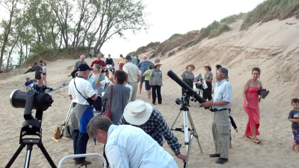 Gary Carlisle with binoculars and Richard Kuschel look for Venus above the cloud bank.