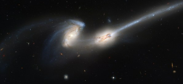 Two galaxies colliding, throwing off tidal tails as they close in.  NGC4686 photo courtesy NASA and the Hubble Space Telescope.