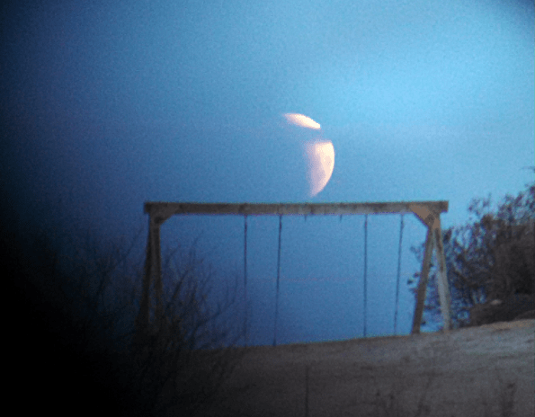 Partially eclipsed Moon setting