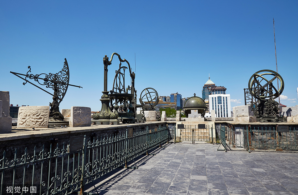 Instruments from the ancient Beijing observatory seen against the background backdrop of the modern architecture of the city.