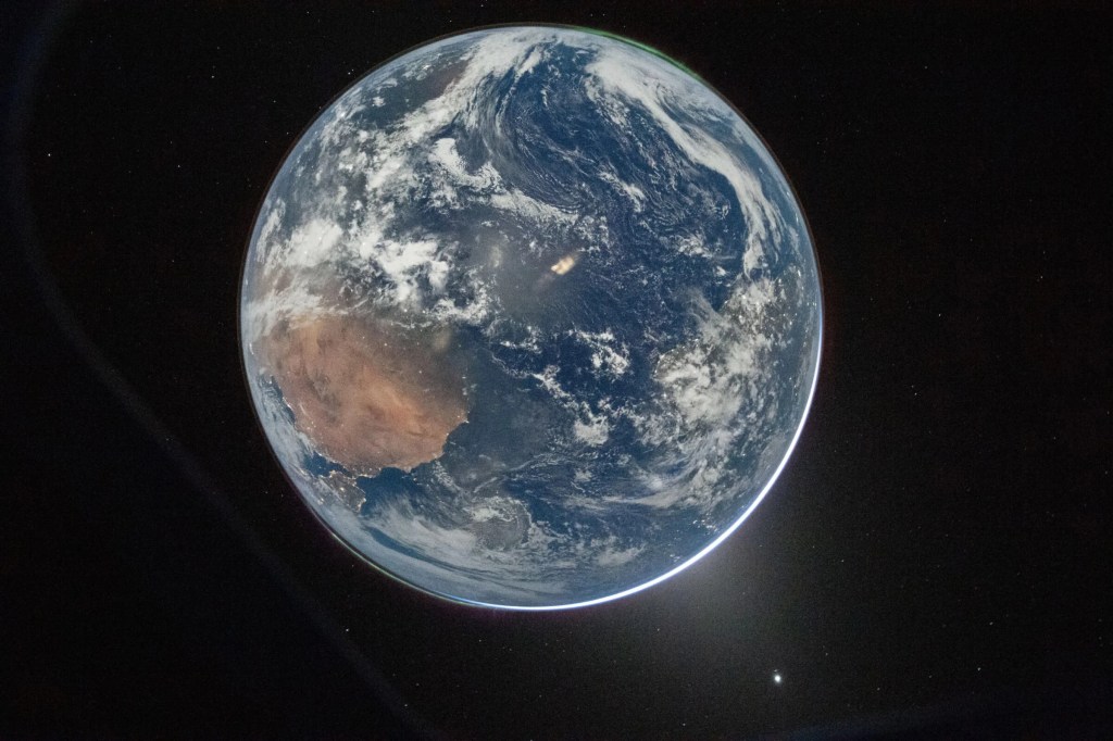 During the first of two solar eclipses witnessed by the Artemis II crew, this time by the Earth. Moonlight by the gibbous Moon illuminates the Earth's night.